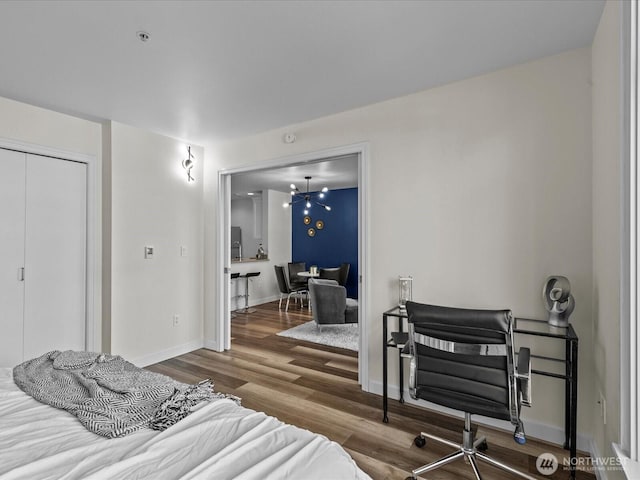 bedroom featuring a closet, wood finished floors, and baseboards