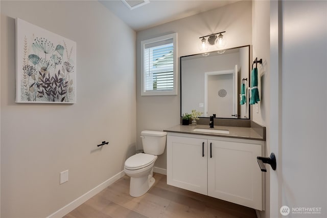 bathroom featuring visible vents, toilet, wood finished floors, baseboards, and vanity