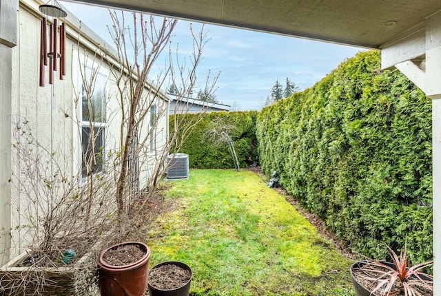 view of yard with central AC unit and fence