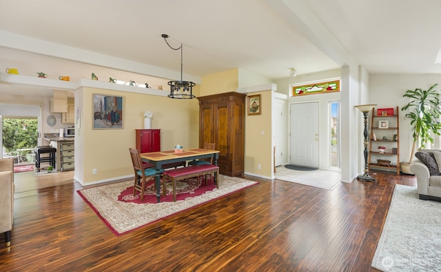 dining room featuring baseboards, a notable chandelier, and wood finished floors