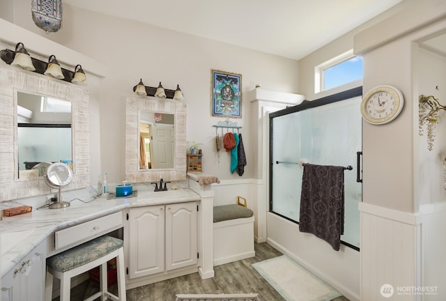 bathroom with vanity, wood finished floors, and a shower with door