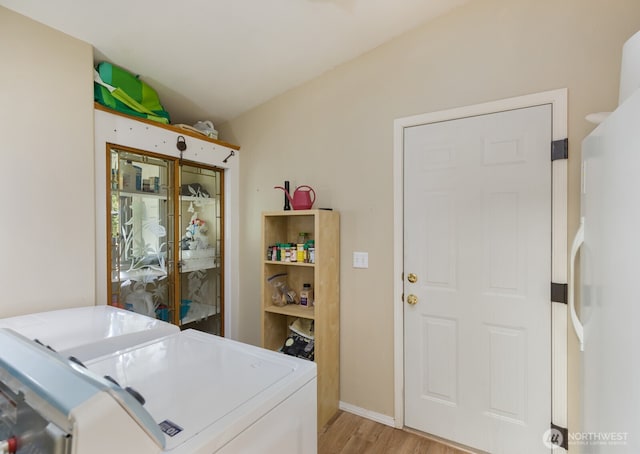 laundry room featuring washing machine and clothes dryer, laundry area, and light wood-style flooring