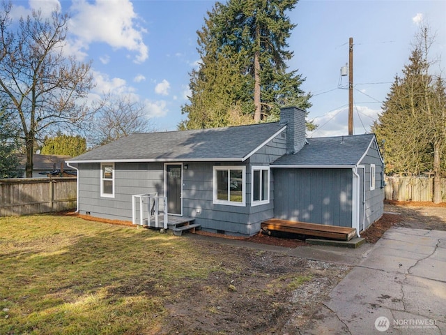 back of house featuring a yard, crawl space, and fence