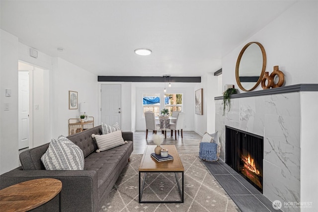 living area with a tile fireplace, baseboards, and wood finished floors