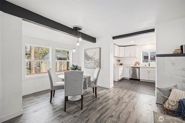 dining room with dark wood finished floors, beamed ceiling, and baseboards