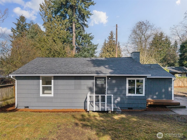 back of property featuring crawl space, a shingled roof, and a yard