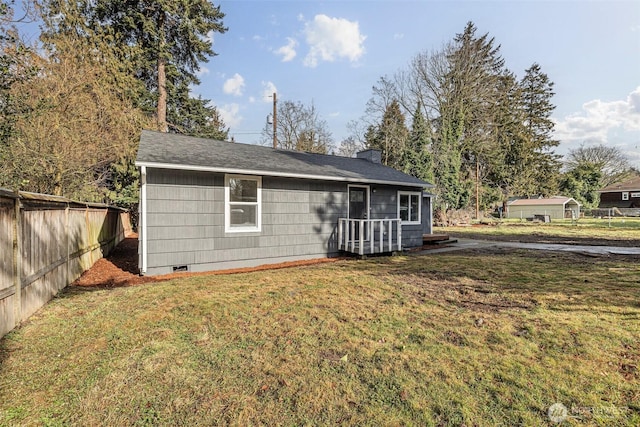 back of house with a yard, crawl space, a chimney, and fence