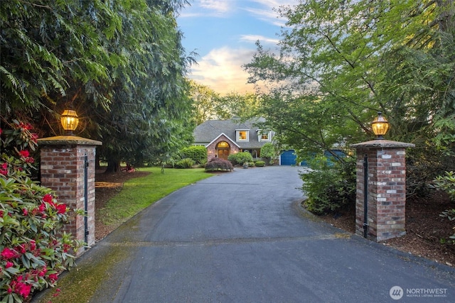 exterior space with aphalt driveway, a front yard, and brick siding