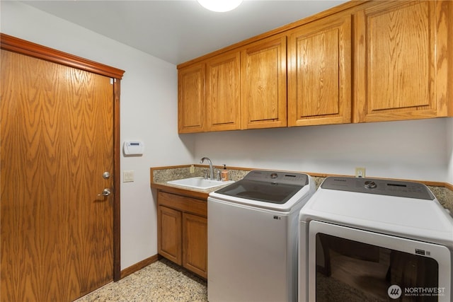 laundry room featuring cabinet space, a sink, baseboards, and separate washer and dryer