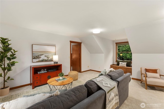 living room featuring lofted ceiling, baseboards, and light colored carpet