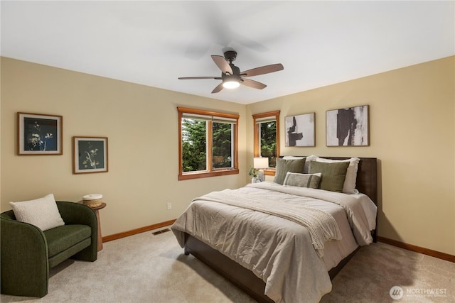 bedroom featuring light carpet, ceiling fan, visible vents, and baseboards