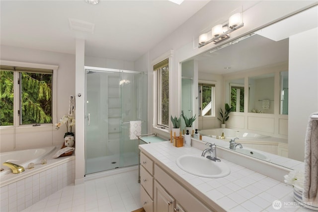 full bathroom featuring tile patterned floors, a garden tub, vanity, and a shower stall