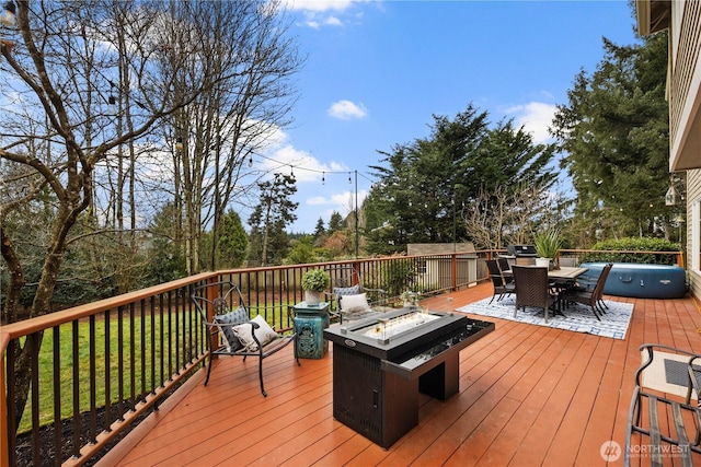 wooden terrace featuring outdoor dining space and a fire pit