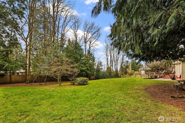 view of yard with fence and a wooden deck