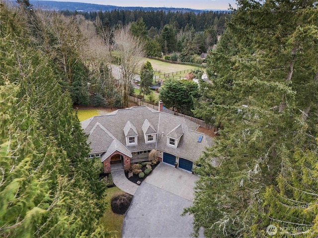 birds eye view of property featuring a forest view