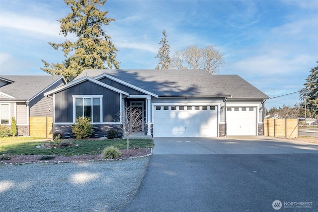 view of front of property featuring board and batten siding, stone siding, driveway, and an attached garage