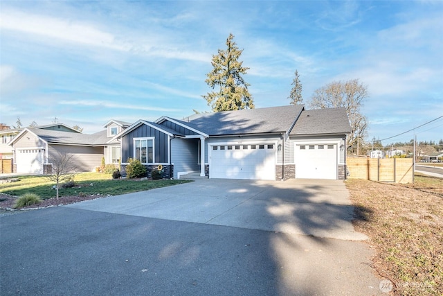 ranch-style house with an attached garage, board and batten siding, fence, stone siding, and driveway