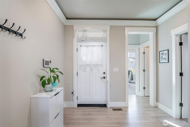 entryway featuring ornamental molding, light wood-style flooring, visible vents, and baseboards