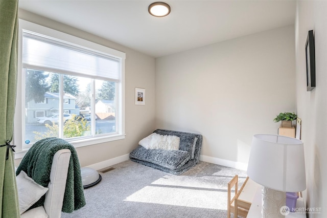 living area featuring carpet floors, visible vents, and baseboards