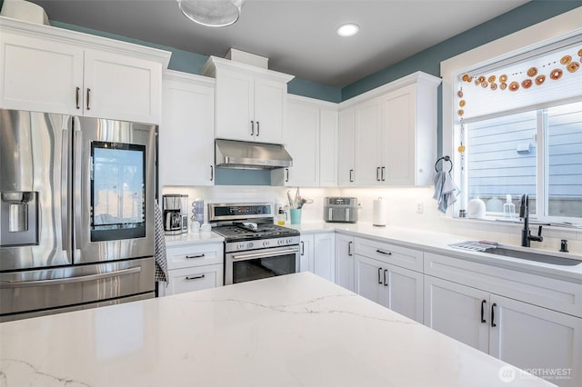 kitchen with stainless steel appliances, a sink, white cabinetry, and under cabinet range hood