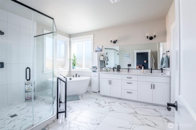 bathroom featuring marble finish floor, double vanity, a sink, and a shower stall