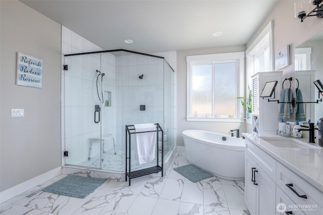 full bath with baseboards, a soaking tub, marble finish floor, vanity, and a shower stall