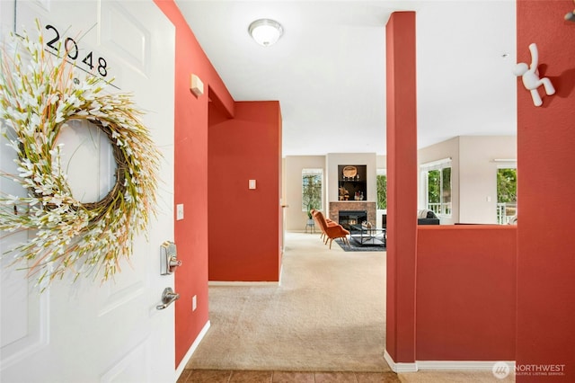 hall with a wealth of natural light, baseboards, and carpet floors