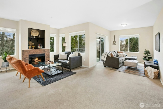 living area featuring baseboards, carpet flooring, and a tile fireplace