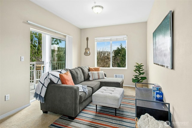 carpeted living area featuring visible vents and baseboards