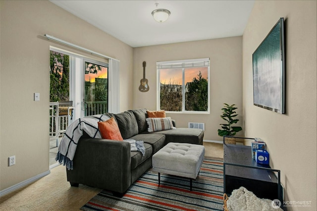 carpeted living area featuring baseboards and visible vents