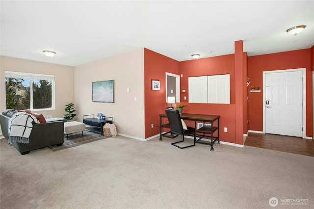 carpeted living area featuring baseboards