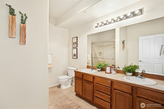 bathroom featuring a shower stall, toilet, double vanity, and a sink