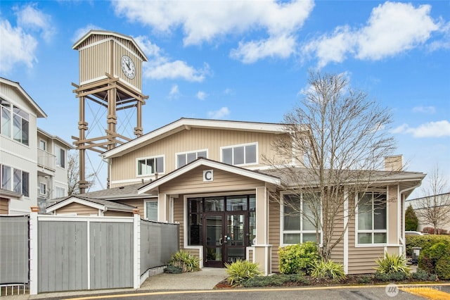 view of front facade featuring a chimney and fence