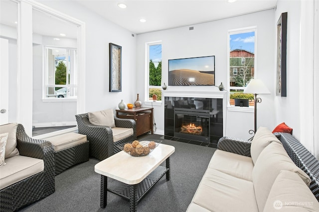 living room featuring recessed lighting, a healthy amount of sunlight, and a tile fireplace