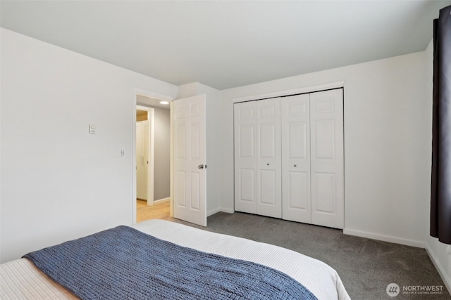 carpeted bedroom featuring baseboards and a closet