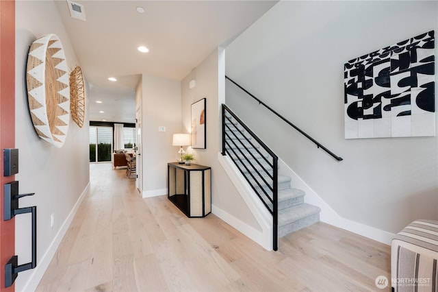 stairway featuring baseboards, wood finished floors, visible vents, and recessed lighting