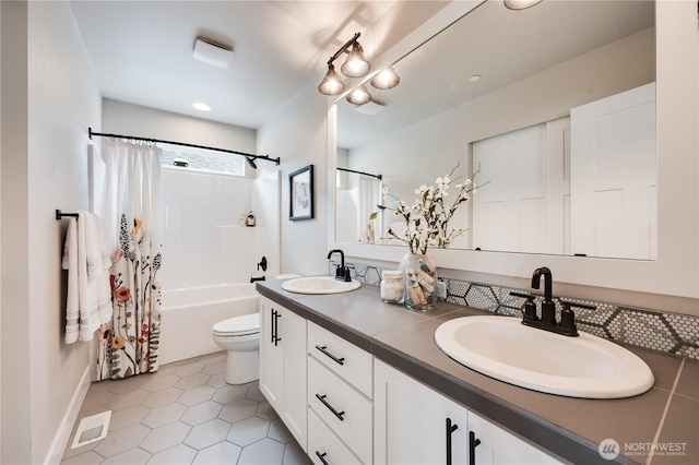 full bathroom featuring double vanity, tile patterned flooring, a sink, and toilet