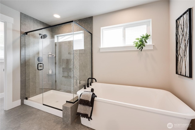 bathroom with a soaking tub, a shower stall, and recessed lighting