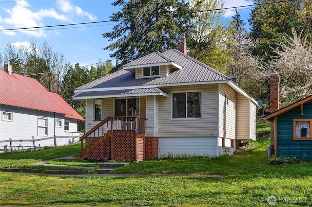 bungalow-style house with metal roof and a front lawn