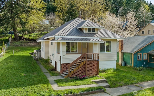 bungalow-style home with a porch, a front yard, and metal roof