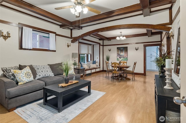 living room with light wood finished floors, baseboards, arched walkways, and beamed ceiling