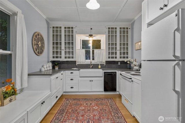 kitchen featuring white appliances, light wood-style flooring, crown molding, white cabinetry, and a sink