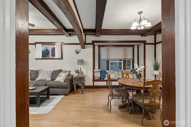 dining room with light wood finished floors, baseboards, a chandelier, and beamed ceiling