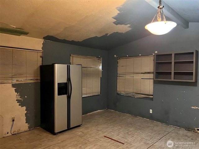 kitchen featuring lofted ceiling, stainless steel refrigerator with ice dispenser, and wood finished floors