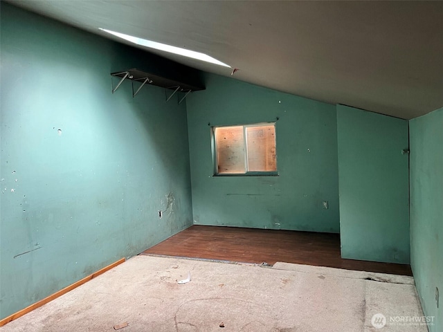 unfurnished room featuring vaulted ceiling