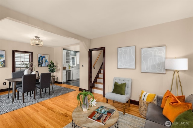 living room with stairway, baseboards, and wood finished floors