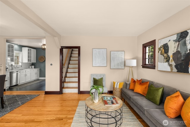 living area with stairway, baseboards, and wood finished floors