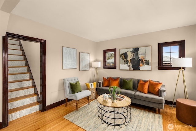 living area with stairs, wood finished floors, and baseboards