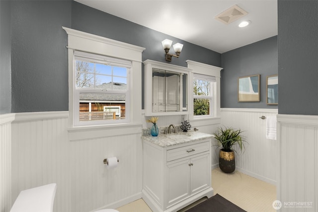 bathroom featuring visible vents, wainscoting, and vanity