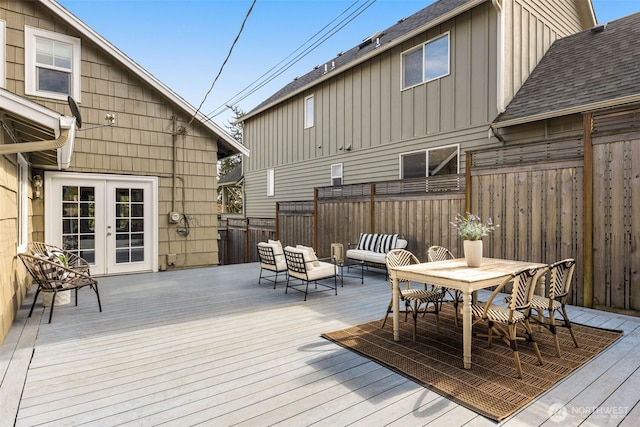 wooden terrace with outdoor lounge area, outdoor dining space, french doors, and fence